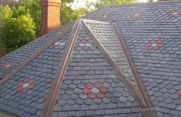 Beveled roof slate installation with different colors and rosette pattern